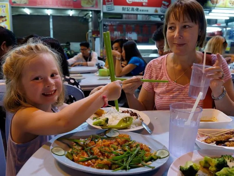 Mutter mit Tochter essen Street Food in Malaysia