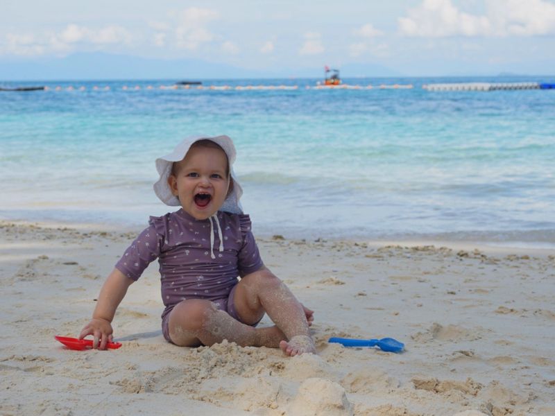 Kleines Mädchen spielt am Strand vom Pulau Redang, Malaysia
