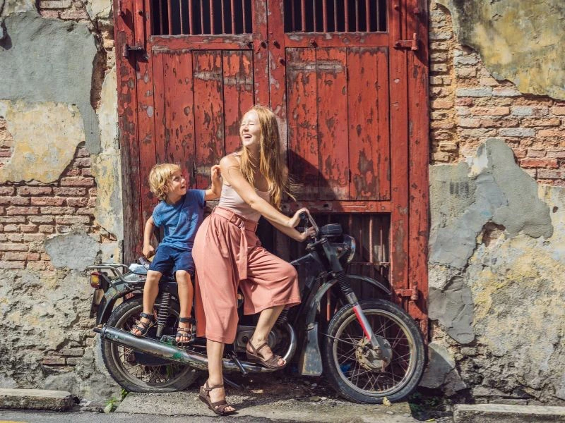 Mutter mit Sohn posieren auf Street Art in Penang, Malaysia