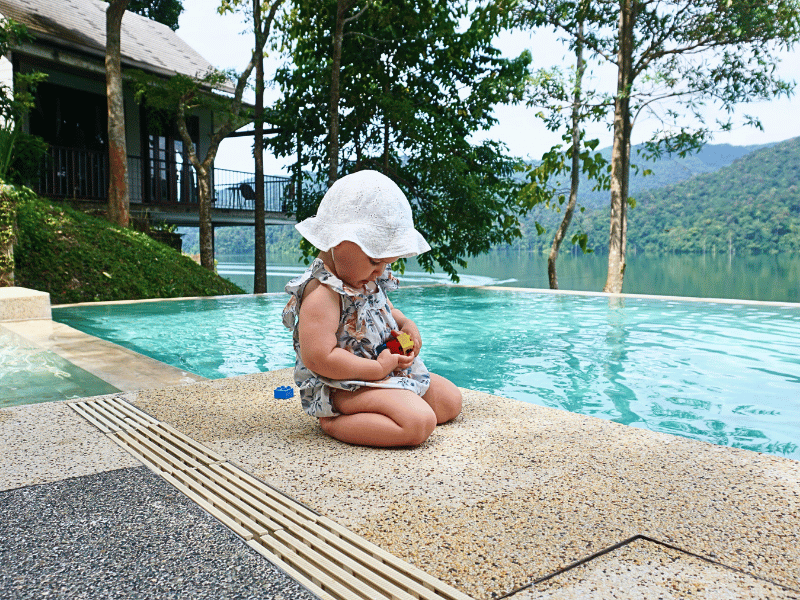 Kleines Kind spielt am Pool im Hotel im Belum Regenwald, Malaysia