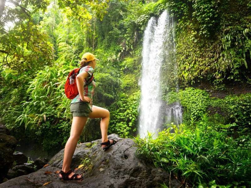 Touristin beim Wandern zum Wasserfall im Endau Rompin Nationalpark in Malaysia