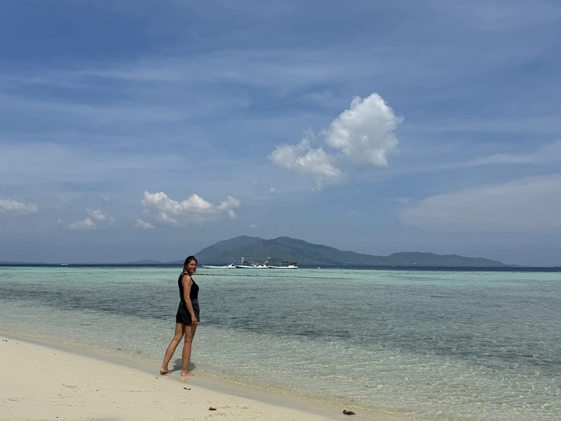 Frau spaziert am Strand in Indonesien