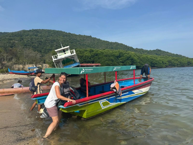 Frau steigt auf ein Boot am Strand in Indonesien