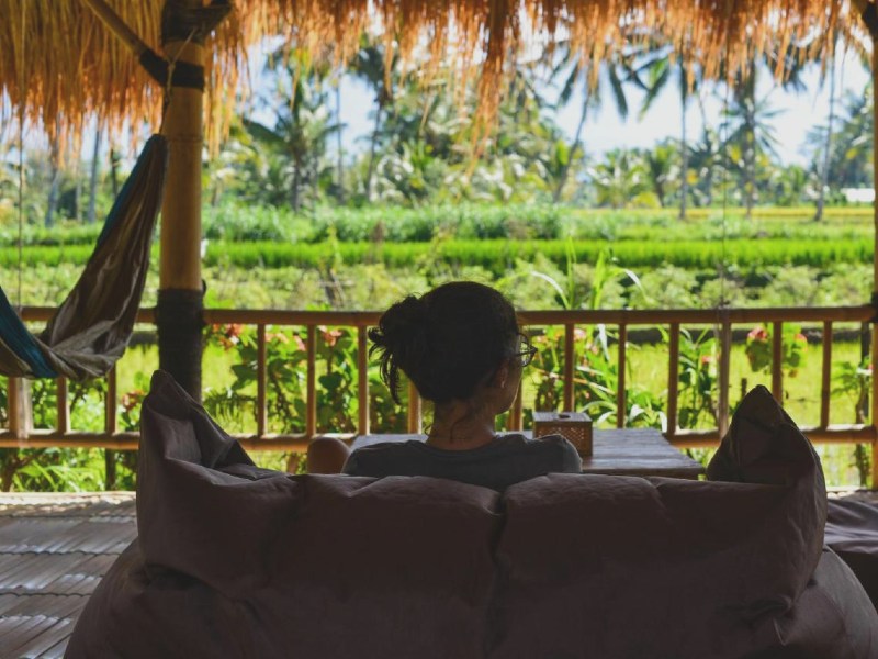 Mädchen entspannt in einem Sitzsack mit Blick auf Reisfeder auf Lombok