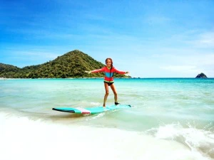 Junges Mädchen beim Surfen in Kuta auf Lombok