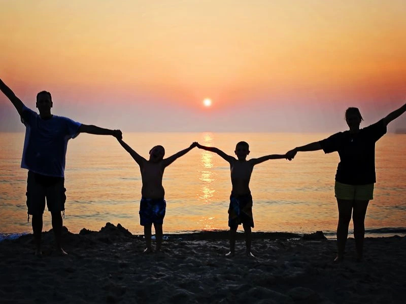 Familie beim Sonnenuntergang am Strand von Lombok, Indonesien