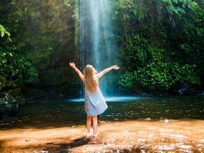 Mädchen vor einem Wasserfall auf Lombok