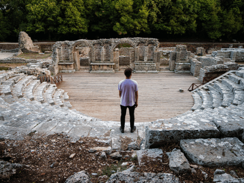 Reisender steht auf Stufen der Ruinen von Butrint