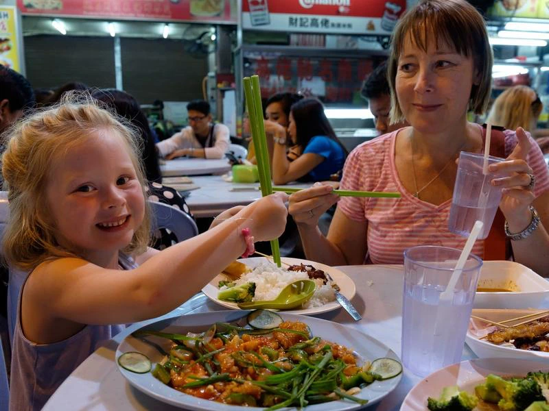 Mutter und Tochter essen mit Stäbchen