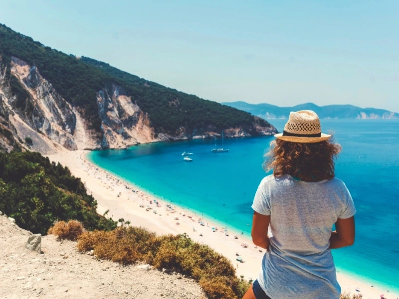 Frau blickt auf türkise Bucht auf Kefalonia