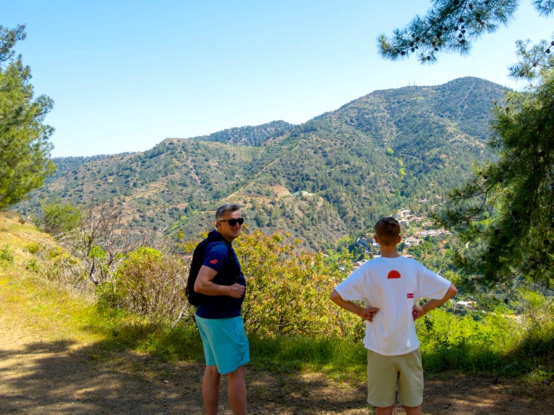 Vater und Sohn in T-Shirt und kurzen Hosen auf einer Wanderung in den Bergen