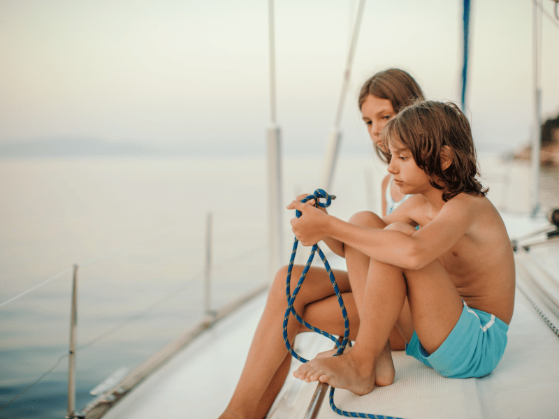 Kinder auf dem Segelboot mit Seil in der Hand, Griechenland