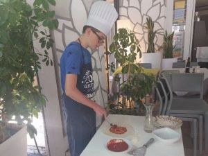 Junge bereitet eigene Pizza zu