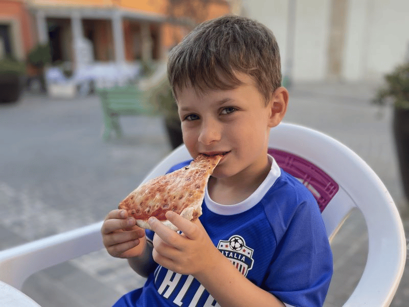 Kind mit Pizza in Sardinien