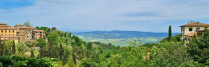 Gebäude auf Hügeln, umgeben von grüner Landschaft