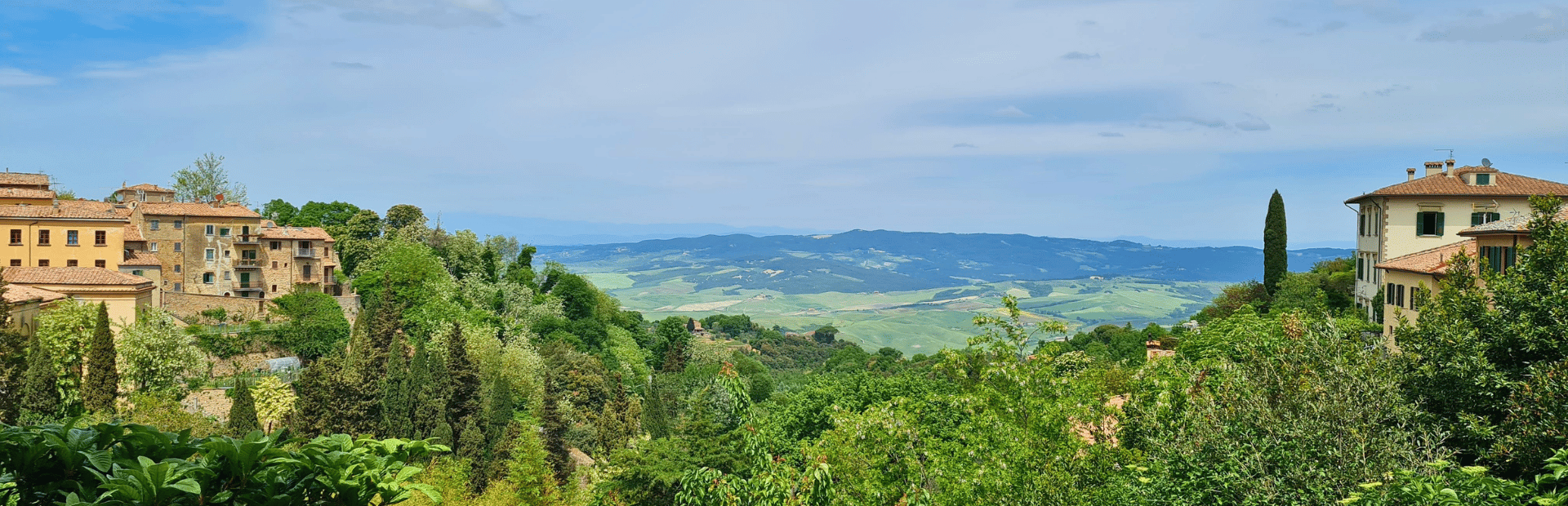 Gebäude auf Hügeln, umgeben von grüner Landschaft