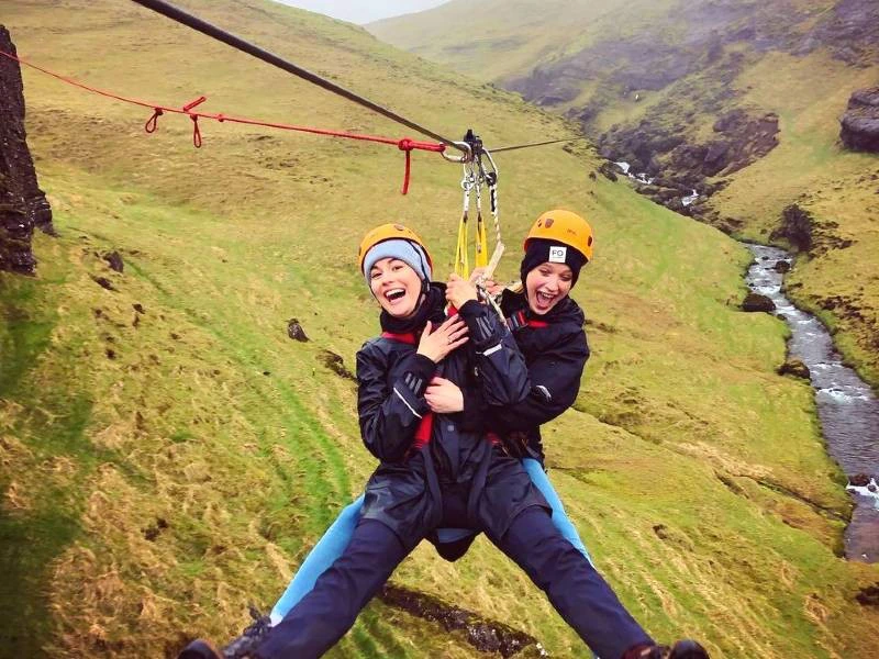 Reisende beim Ziplining in Island
