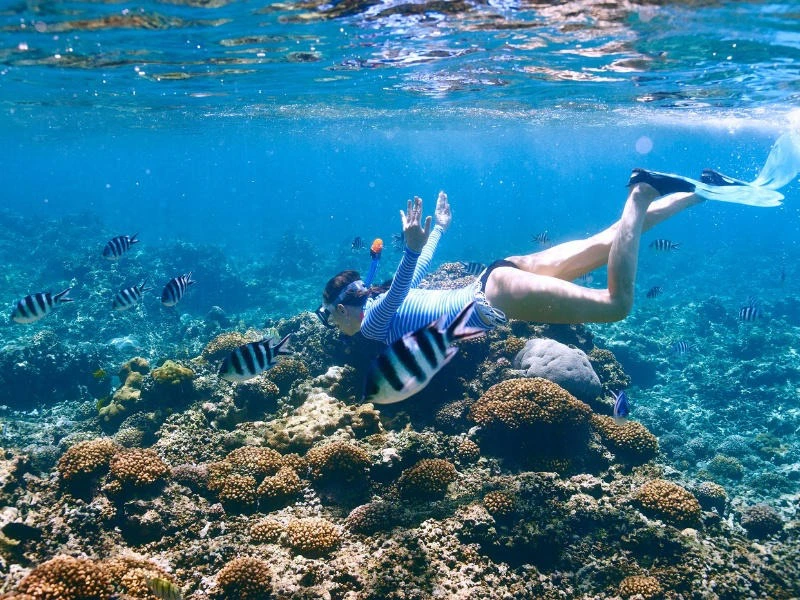 Frau schnorchelt durchs Korallenriff vor Caye Caulker