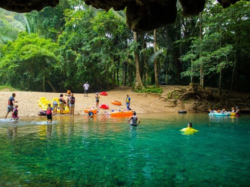 Gruppe mit Tubes am Ufer und im Fluss