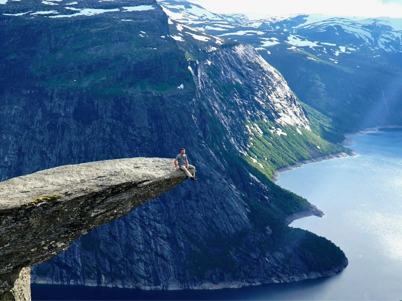 Auf der Trollzunge sitzen ĂĽber dem Fjord in Norwegen