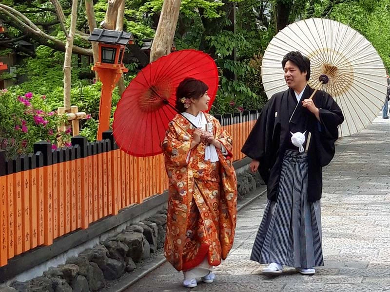 Japanisches Paar in Kimonos und mit Sonnenschirmen in Kyoto in Japan