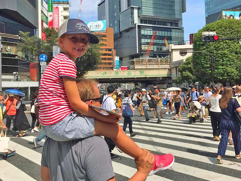 Sohn auf den Schultern seines Vaters bei Shibuya Crossing in Tokio