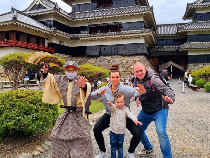 Familie macht Samurai Gesten vor Burg in Japan
