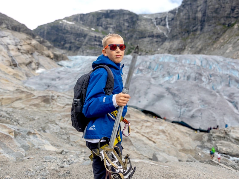 Kind mit Ausrüstung vor Gletscher