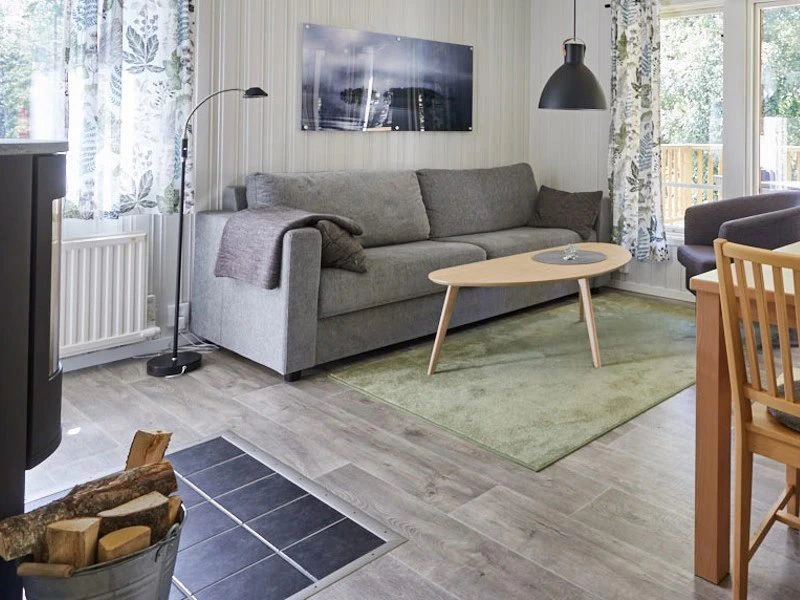 Gemütliches Wohnzimmer mit einer grauen Couch und Holztisch in Småland