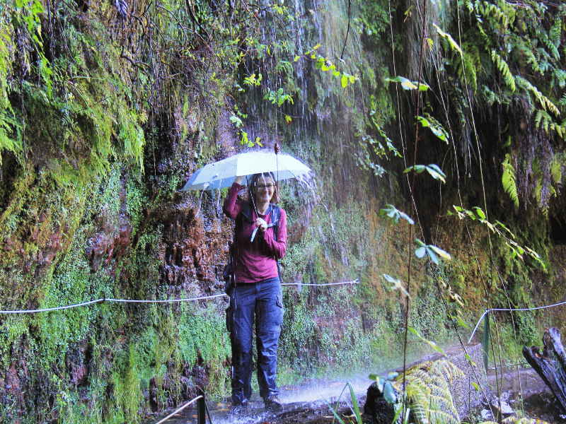 Frau unter Wasserfall in Madeira