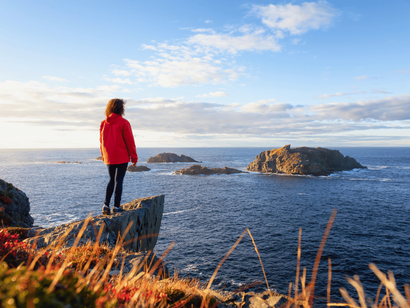 Frau schaut aufs Meer bei Twillingate in Kanada