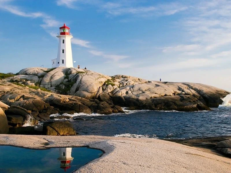 rot-weißer Leuchtturm spiegelt sich im Wasser an Peggy´s Cove in Kanada