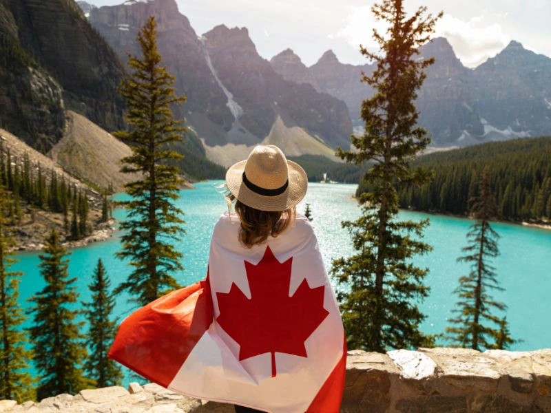 Reisende mit der Kanada Flagge in den Rocky Mountains in Kanada