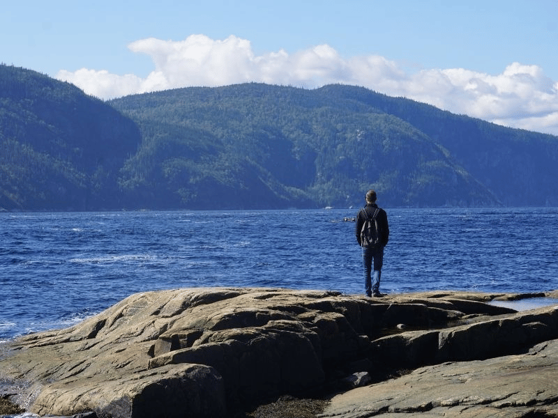 Reisender am Wasser bei Tadoussac, Kanada