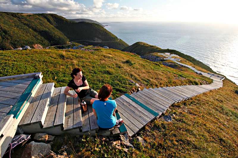Zwei Reisende an der Küste von Cape Breton mit Blick aufs Meer