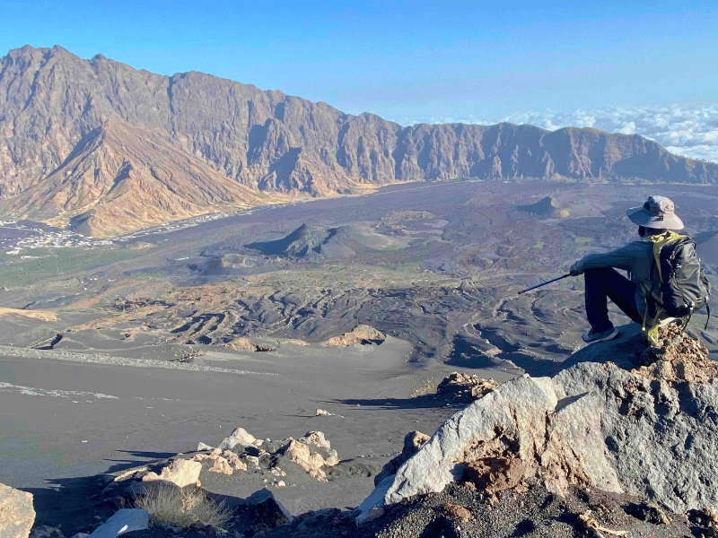 Reisender sitzt am Pico do Fogo Vulkan und geniesst die Aussicht