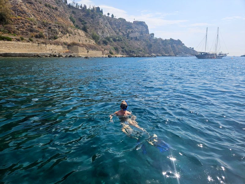 Frau schnorchelt im Wasser in Sizilien