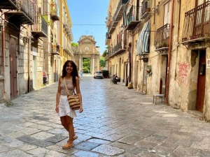 Frau steht in einer Straße mit Kopfsteinpflaster in Palermo in Sizilien