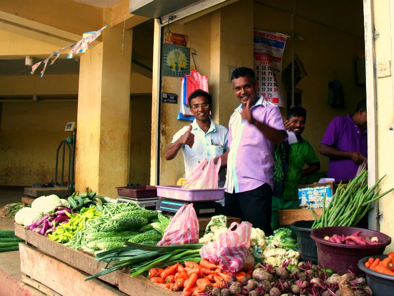 Verkäufer an einem Gemüsestand auf einem Markt in Sri Lanka