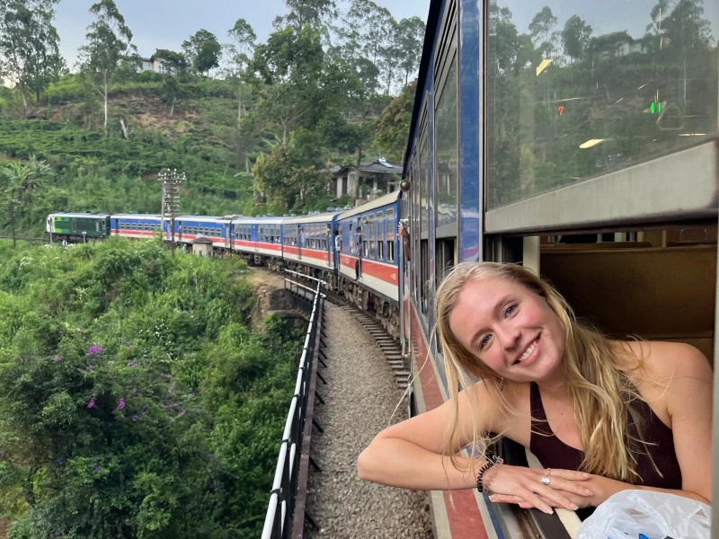 Junges Mädchen schaut aus dem Zugfenster in Sri Lanka