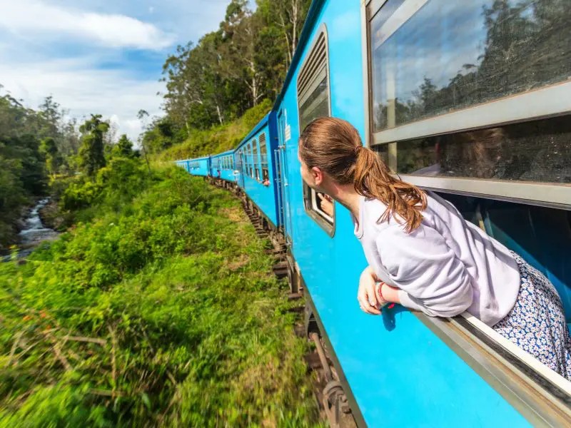 Frau schaut aus dem Zugfenster in Sri Lanka