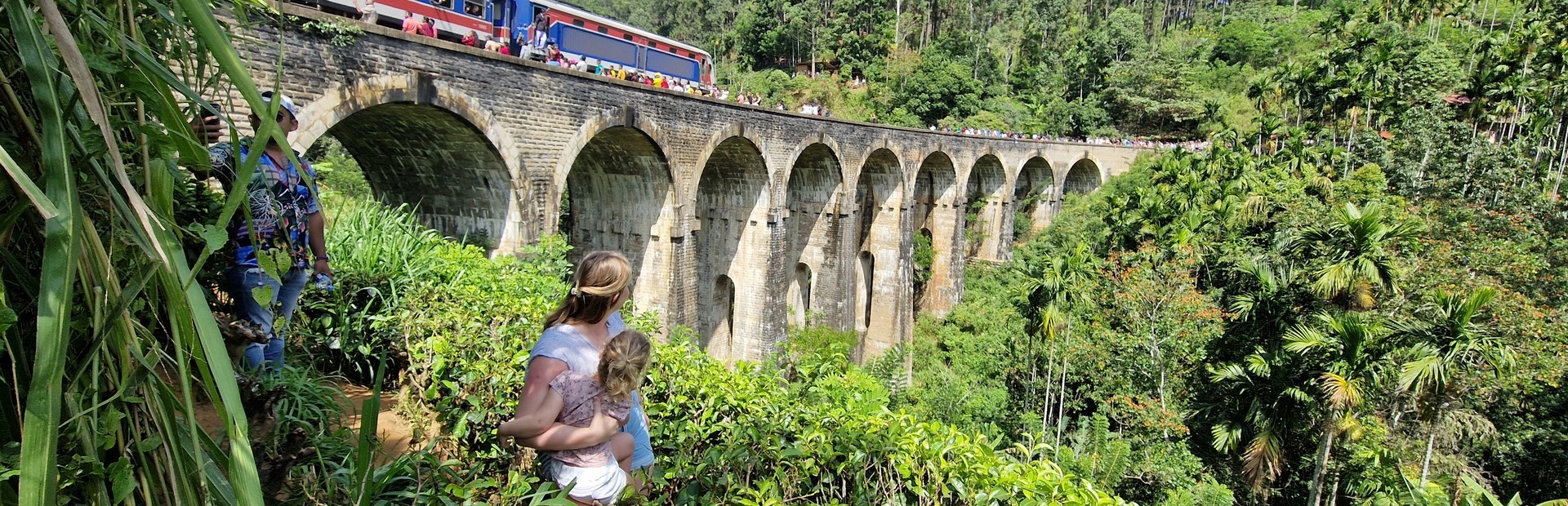 Frau mit kleiner Tochter vor der Nine Arches Bridge in Ella