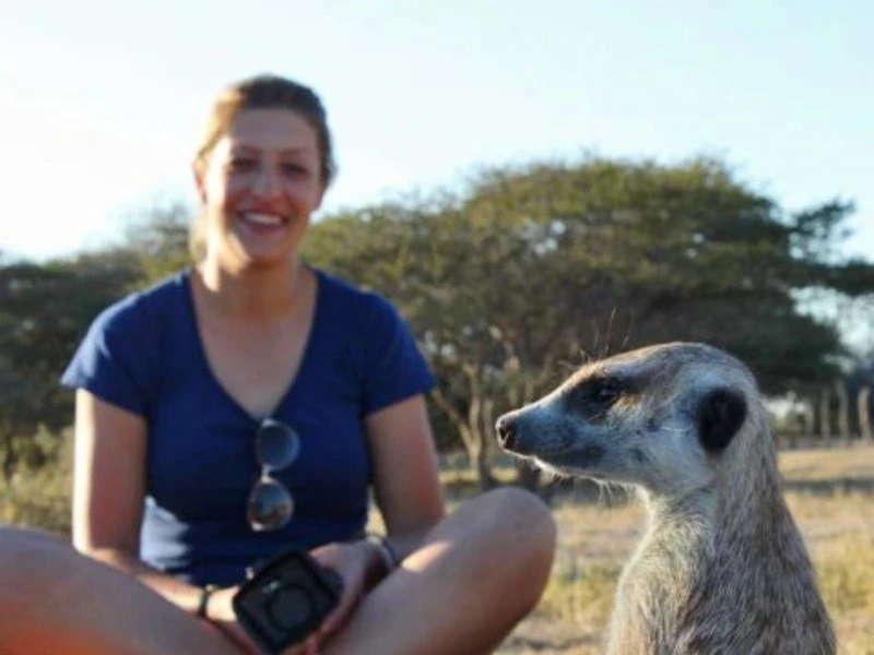 Namibia Kalahari Reisende ganz nah an einem Erdmännchen im Busch