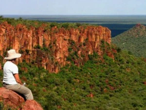 Namibia Waterberg Familienreise National Park reisender sitzt auf einem Fels mit Blick auf den Nationalpark