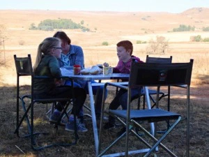 Namibia Okavango Fluss Familienreise reisende sitzen am Tisch und essen.