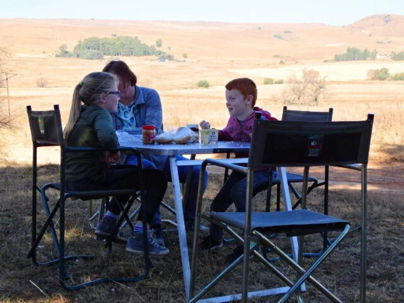 Namibia Okavango Fluss Familienreise reisende sitzen am Tisch und essen.