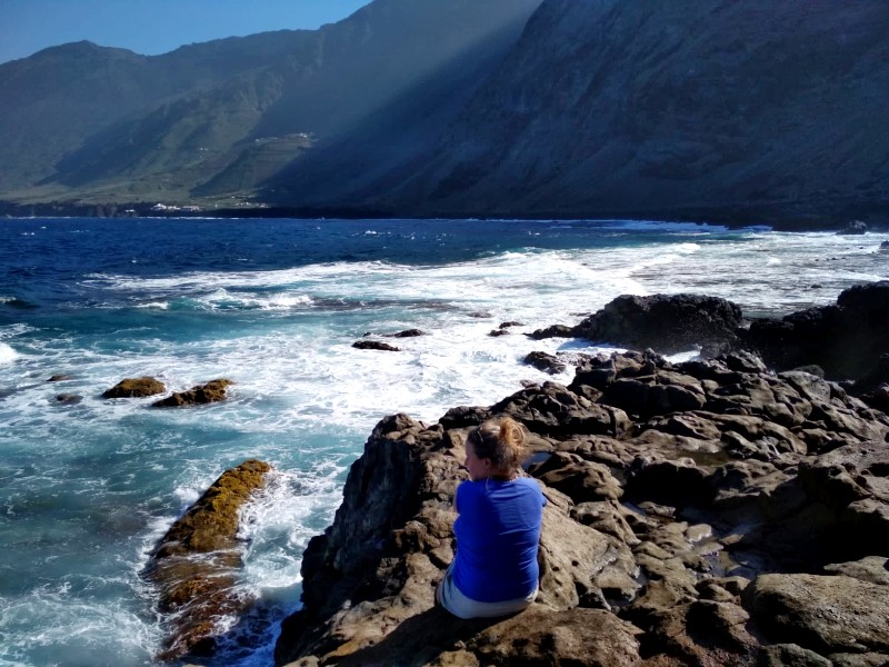 Kanarische Inseln El Hierro reisende auf einem Felsen in einer Bucht umgeben von Bergen