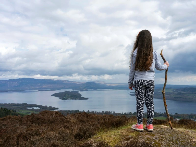 Mädchen mit Wanderstock bei Loch Lomond, Schottland