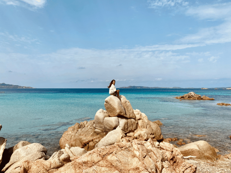 Reisende auf Steinen am Meer bei Maddalena, Sardinien