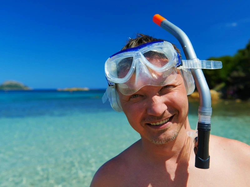 Mann mit Schnorchelausrüstung auf Maddalena, Sardinien